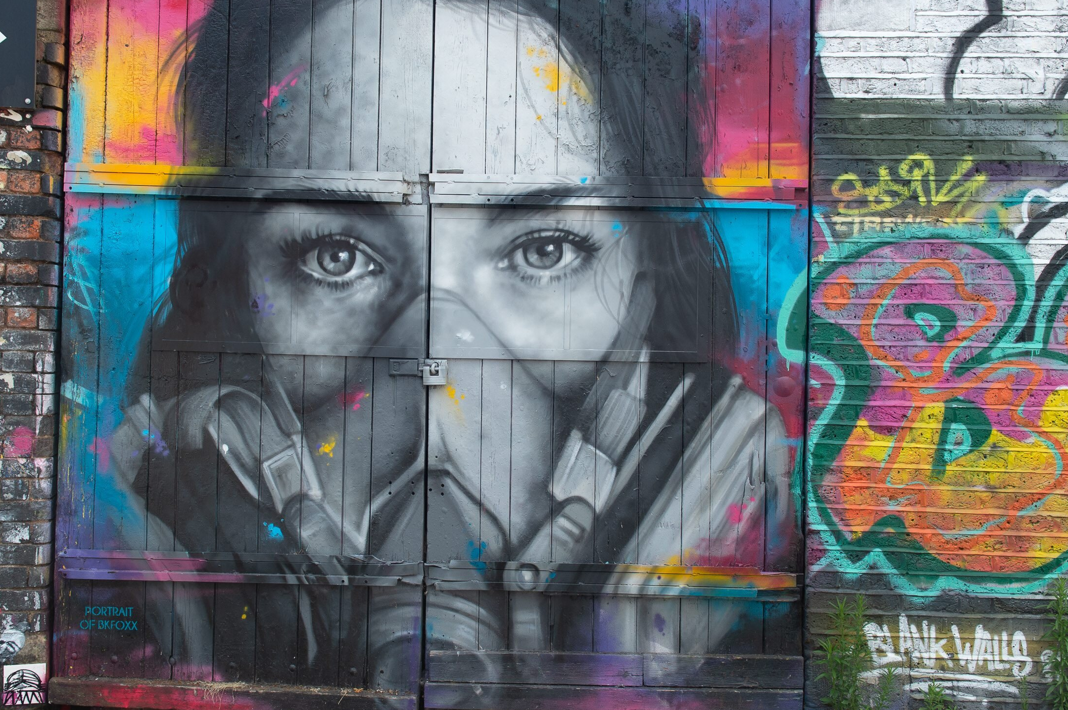 Das Graffiti des Straßenkünstlers Zabou zeigt eine junge Frau mit Maske.