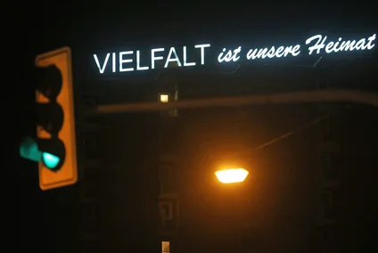 The light installation entitled ‘Diversity is our strength’ by artist Christoph Stark shines from the roof of a high-rise building. The words Diversity is our home can be read.