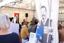 Blick in das Pavillionzelt der FES, in welchem Menschen einem Vortrag zuhören.