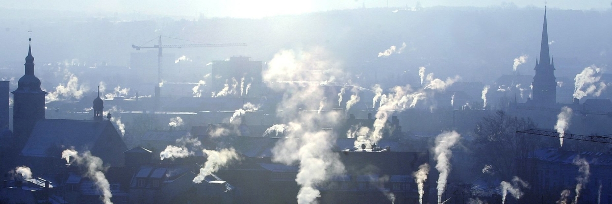 Häuserdächer mit rauchenden Schornsteinen
