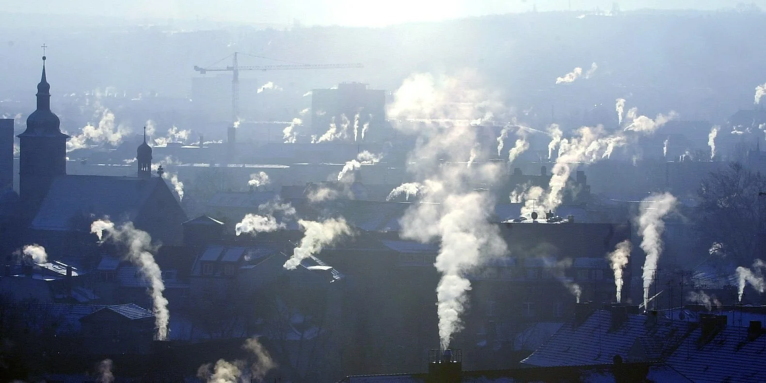 Häuserdächer mit rauchenden Schornsteinen