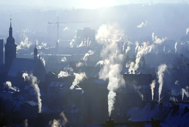 Häuserdächer mit rauchenden Schornsteinen