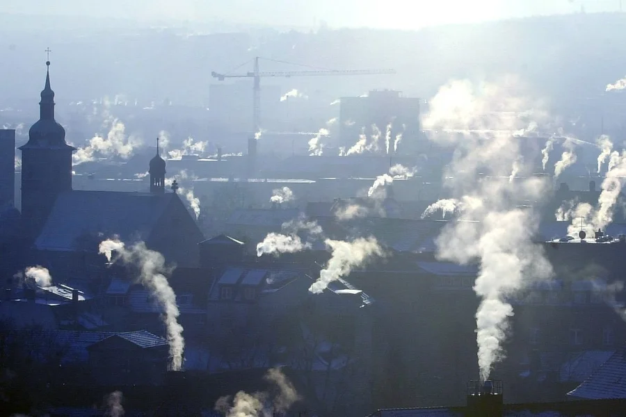 Häuserdächer mit rauchenden Schornsteinen